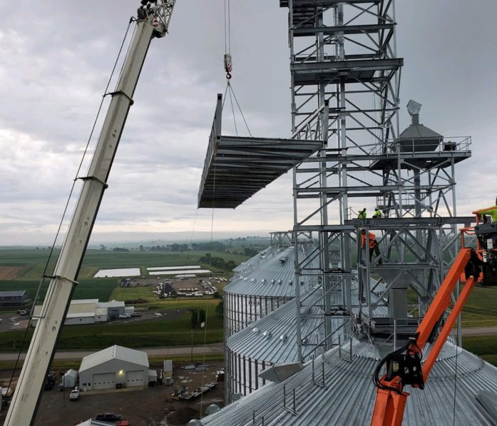 Crane lifting a walkway up a grain elevator